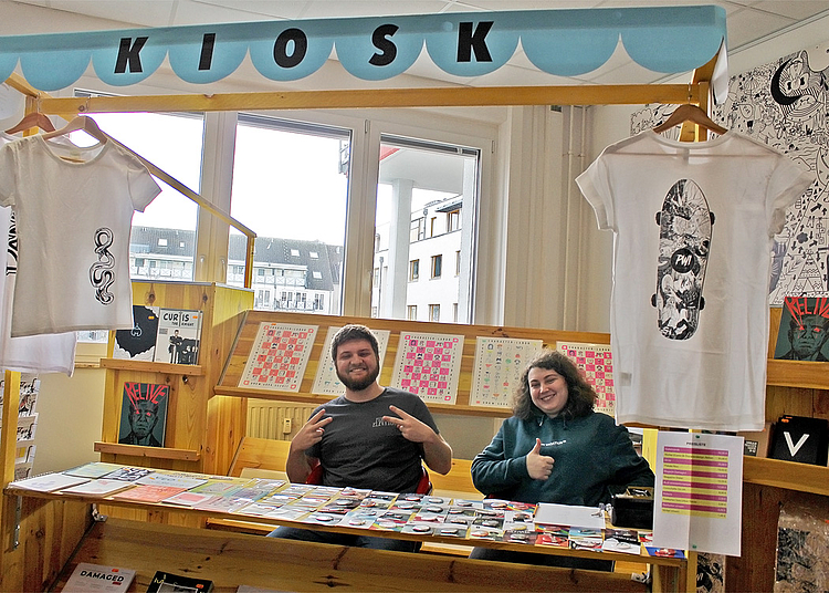 Studierende der HMKW Köln im Kiosk mit Büchern, Prints, T-Shirts und mehr Produktionen aus den Design-Projekten.