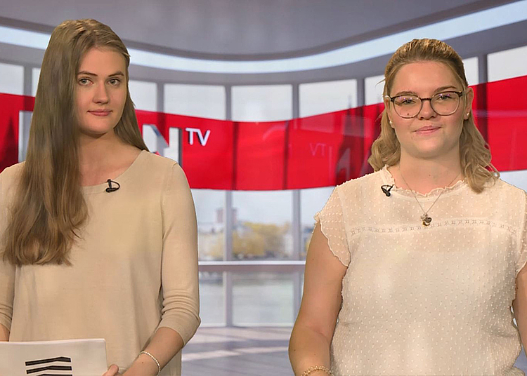 Das Bild ist ein Screenshot aus der Plan-TV-Episode und zeigt die Studierenden Celina und Laura, die diese Plan-TV-Ausgabe moderiert haben.