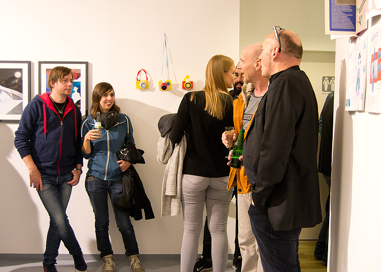 Besucher/innen in der neu eröffneten Galerie Hundert am Höninger Weg 100a, darunter Design-Professor Dr. Markus Schröppel (re.)